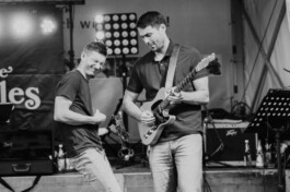 Zwei Musiker von Benjoe and the Miracles in einem energiegeladenen Bühnenmoment 
