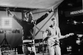 Sänger von Benjoe and the Miracles mit Mikrofon und ausgebreiteten Armen auf der Bühne 